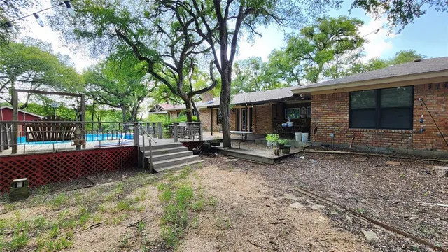 a view of a bench in the backyard with wooden fence