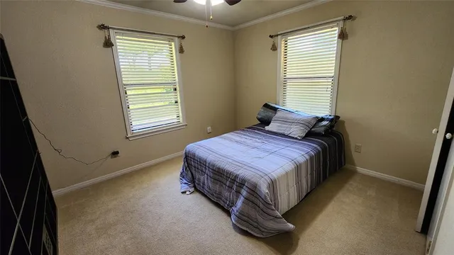 a bed sitting in a bedroom next to a window