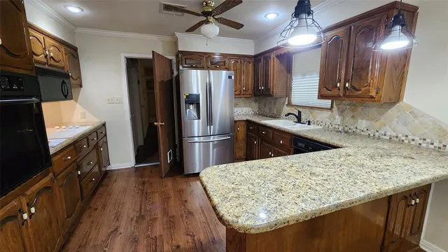 a kitchen with stainless steel appliances granite countertop a sink refrigerator and microwave