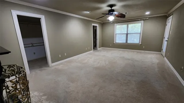 en empty room with windows and ceiling fan
