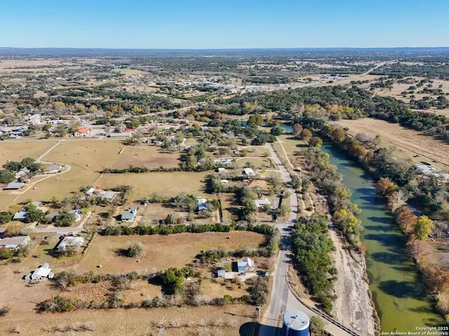 an aerial view of ocean and residential houses with outdoor space