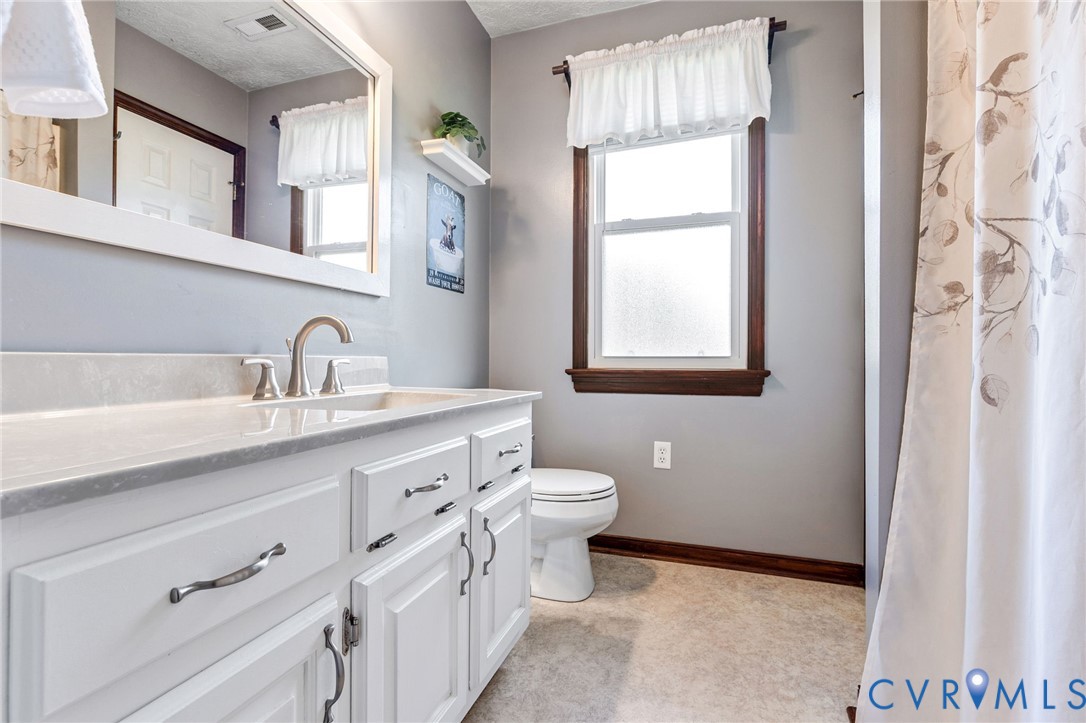 3411 Spring Run Road Mechanicsville, VA 23111 - Photo 17 of 41 a bathroom with a double vanity sink a toilet and a mirror