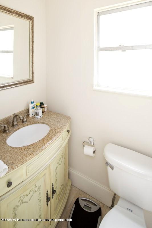 339 Cocoanut Row Palm Beach, FL 33480 - Photo 22 of 25 a bathroom with a granite countertop sink toilet and a mirror