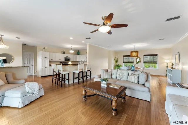 a kitchen with white cabinets a sink dishwasher and a stove with wooden floor