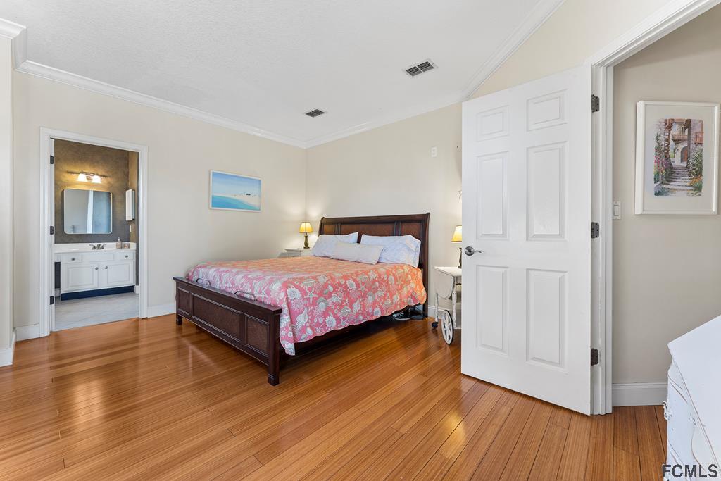 7619 A1A South St. Augustine, FL 32080 - Photo 19 of 51 a bedroom with a bed and wooden floor