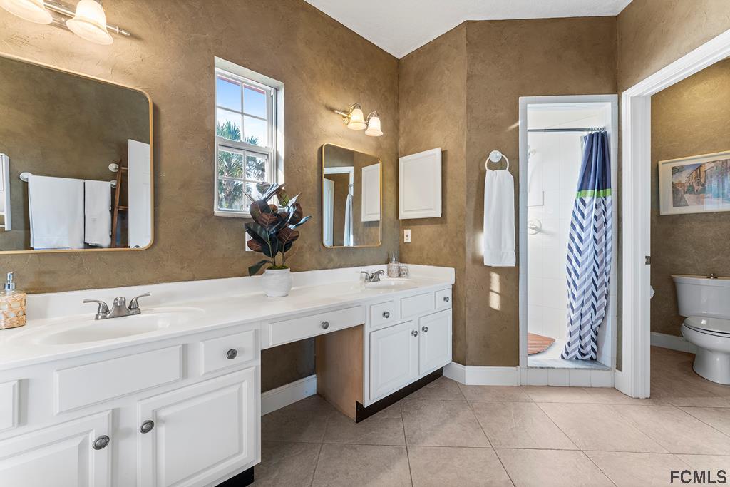 7619 A1A South St. Augustine, FL 32080 - Photo 21 of 51 a bathroom with a double vanity sink mirror and toilet