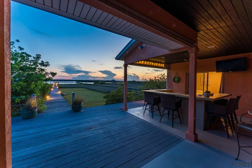 7619 A1A South St. Augustine, FL 32080 - Photo 30 of 51 a view of a patio with table and chairs potted plants with wooden floor
