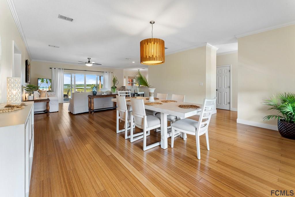 7619 A1A South St. Augustine, FL 32080 - Photo 8 of 51 a dining room with wooden floor a chandelier a glass table and chairs