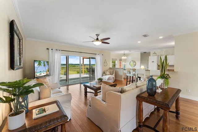 a living room with furniture a potted plant and a large window