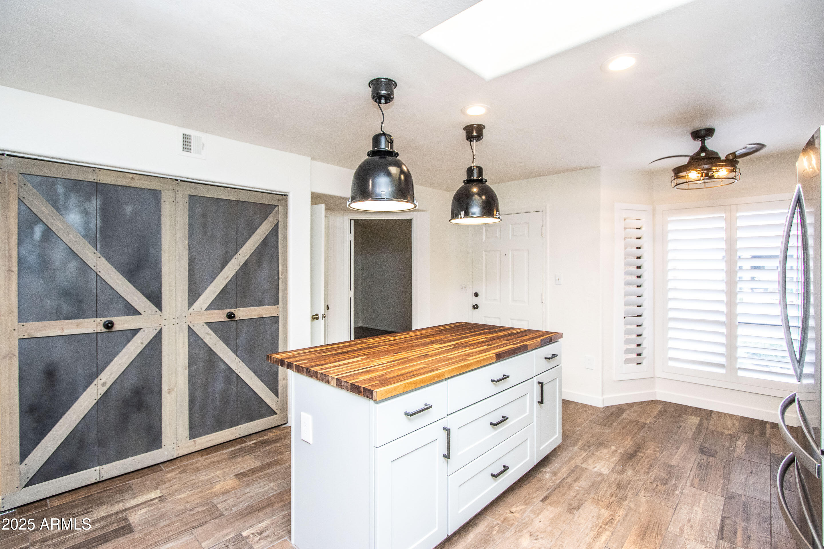 1318 East Cobb Drive Tempe, AZ 85288 - Photo 11 of 43 a kitchen with white cabinets and wooden floors