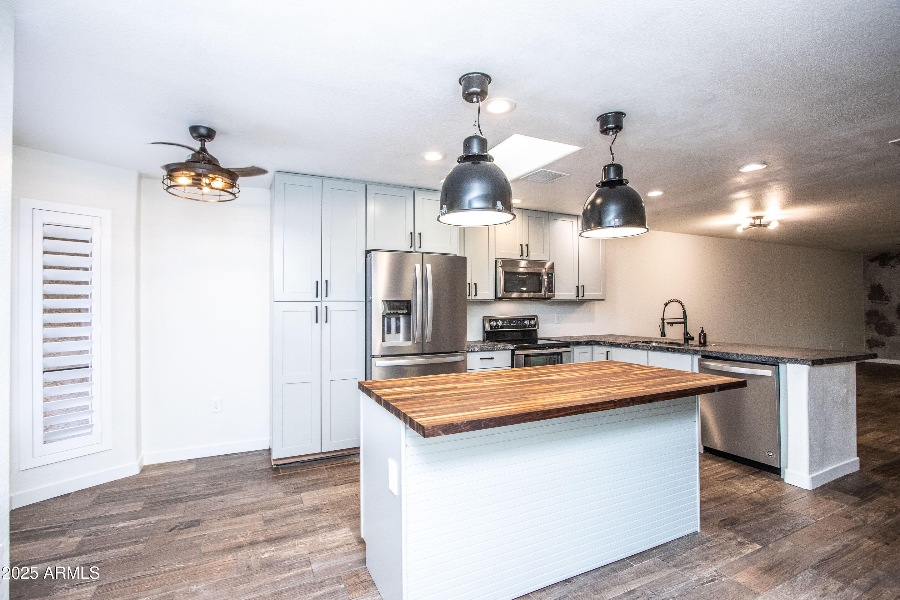 1318 East Cobb Drive Tempe, AZ 85288 - Photo 12 of 43 a kitchen with stainless steel appliances a sink a stove a refrigerator and island