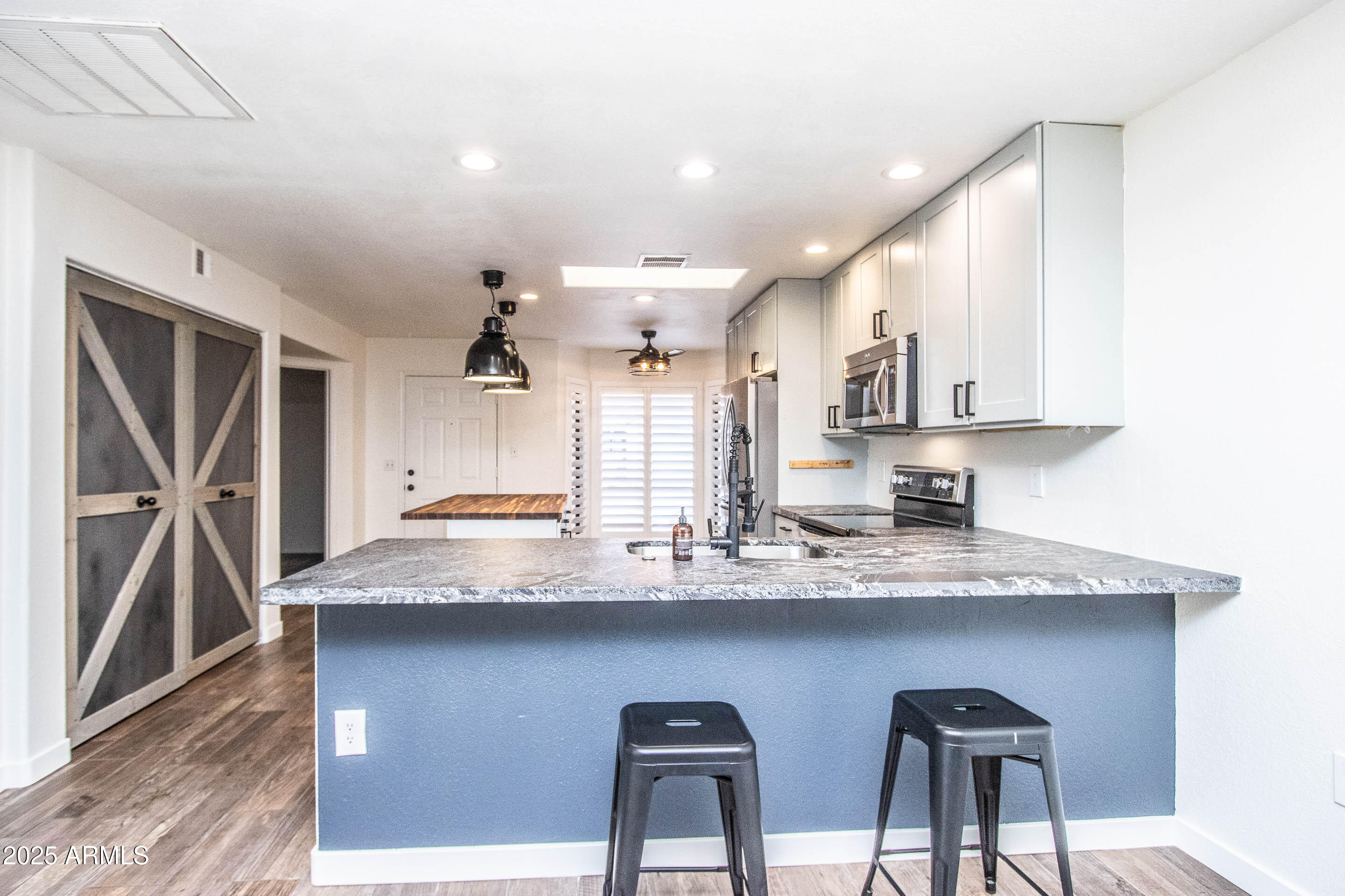 1318 East Cobb Drive Tempe, AZ 85288 - Photo 15 of 43 a kitchen with stainless steel appliances granite countertop a sink a stove and a wooden cabinets