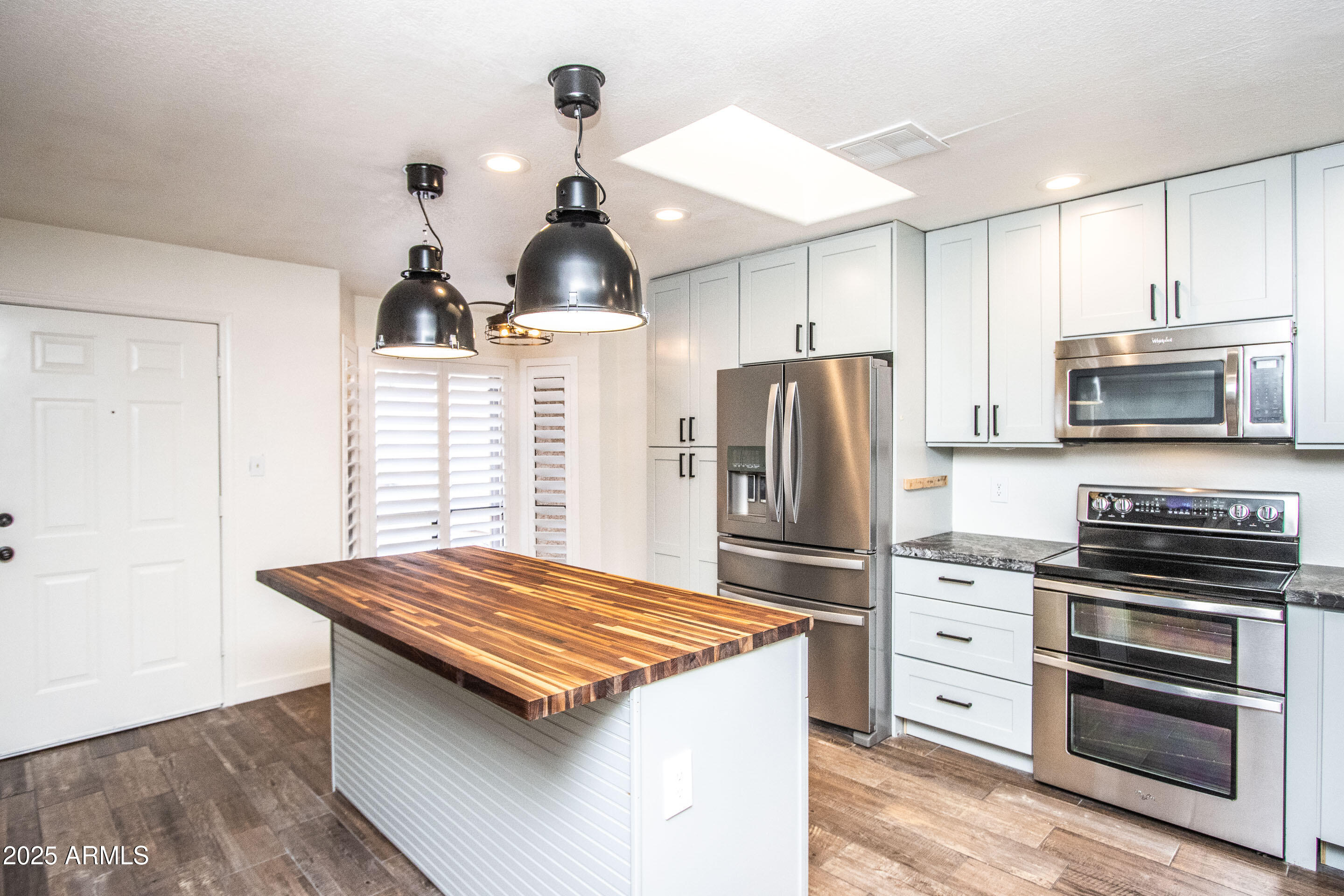 1318 East Cobb Drive Tempe, AZ 85288 - Photo 2 of 43 a kitchen with stainless steel appliances kitchen island granite countertop a stove refrigerator and cabinets