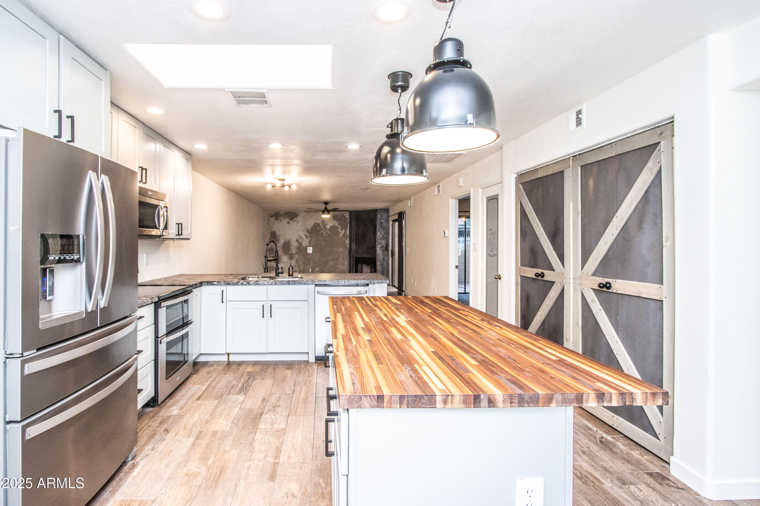 1318 East Cobb Drive Tempe, AZ 85288 - Photo 4 of 43 a kitchen with stainless steel appliances kitchen island granite countertop a refrigerator and a sink
