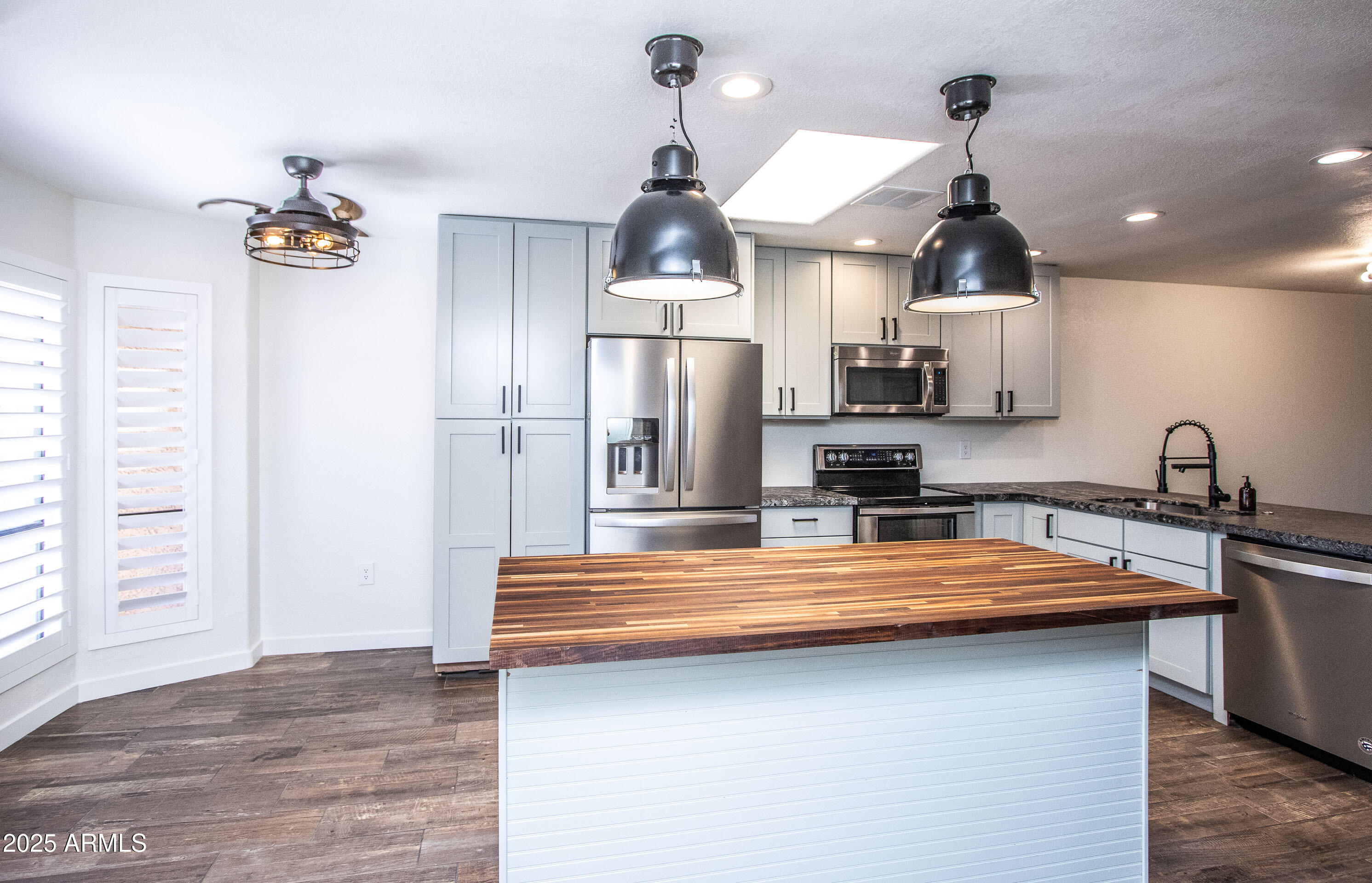 1318 East Cobb Drive Tempe, AZ 85288 - Photo 5 of 43 a kitchen with stainless steel appliances a refrigerator sink and cabinets