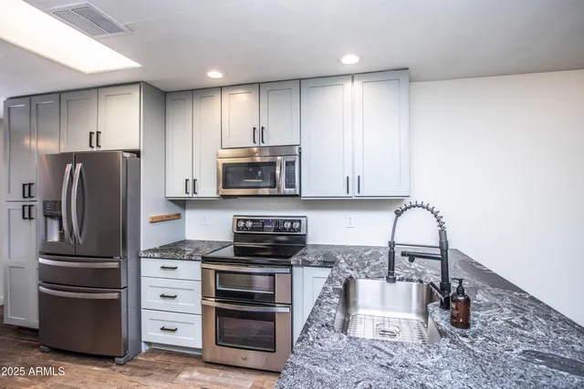 a kitchen with stainless steel appliances a stove a refrigerator and a microwave