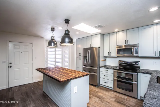 a kitchen with kitchen island a sink stainless steel appliances and counter space