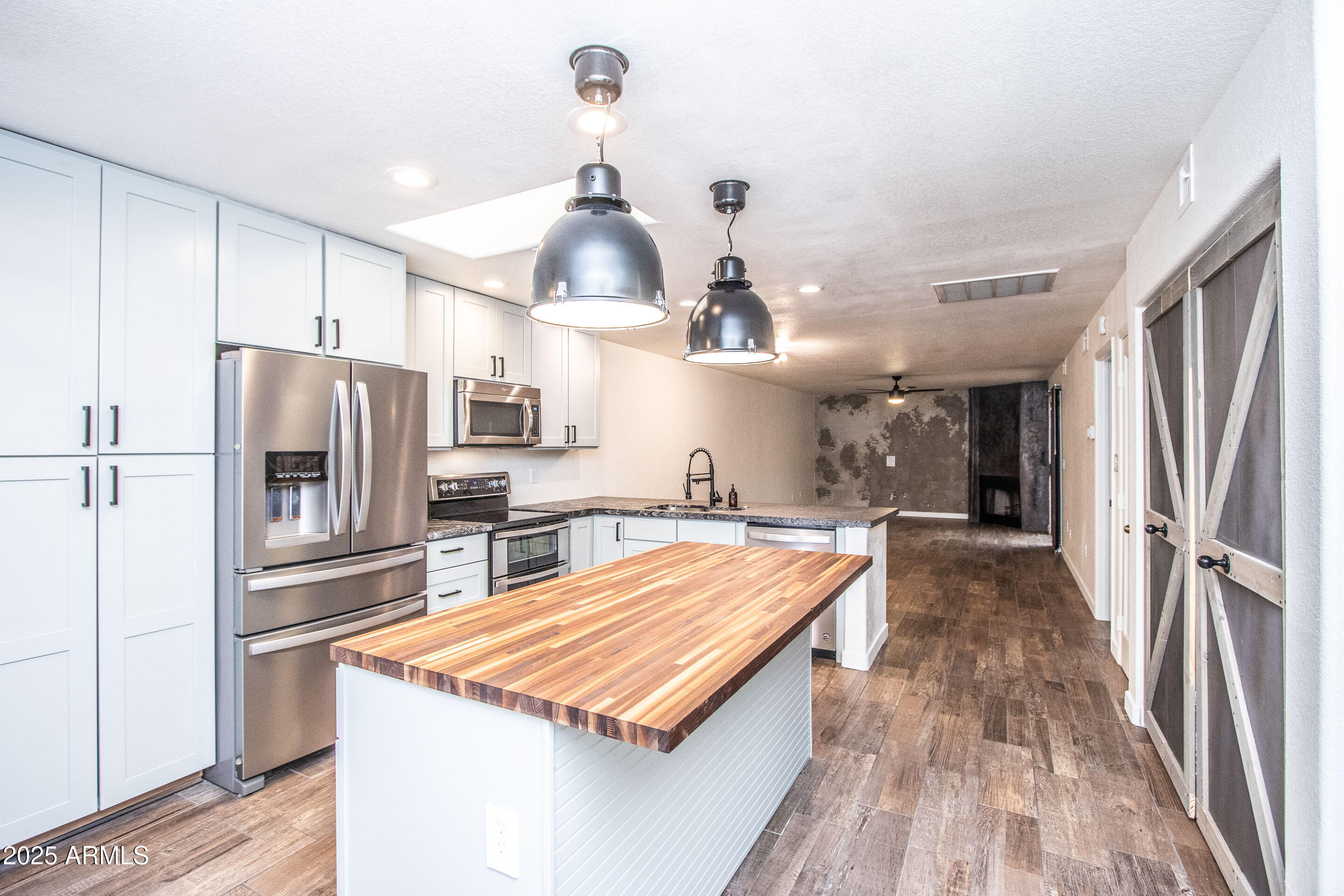 1318 East Cobb Drive Tempe, AZ 85288 - Photo 9 of 43 a kitchen with stainless steel appliances a kitchen island hardwood floor and a sink
