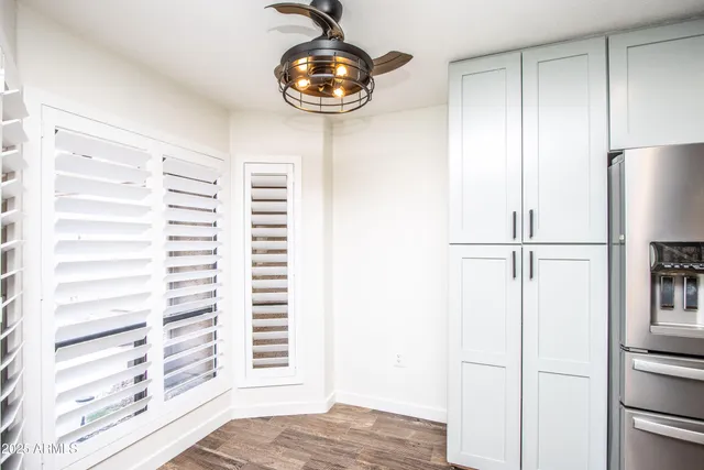 a kitchen with white cabinets and wooden floors