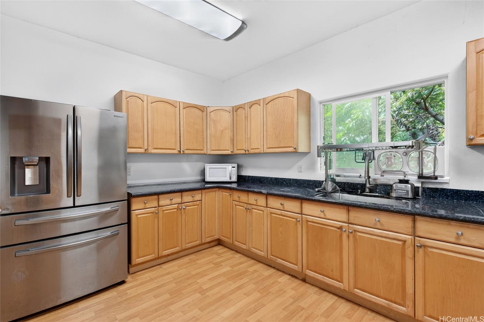 2802 Numana Road Honolulu, HI 96819 - Photo 9 of 18 a kitchen with granite countertop white cabinets and a sink