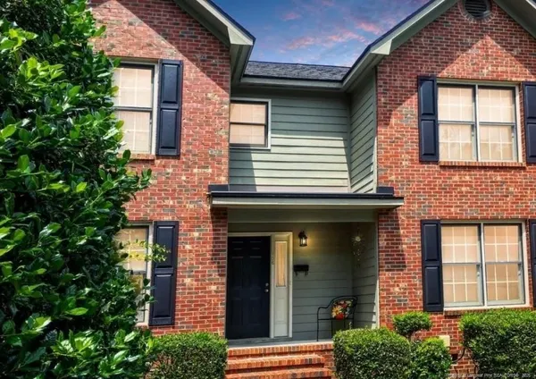 front view of a brick house with a small yard