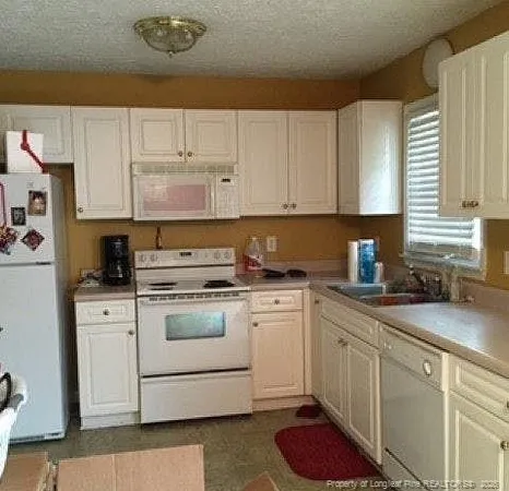 a kitchen with cabinets appliances a sink and a window