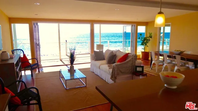 a living room with furniture and floor to ceiling windows