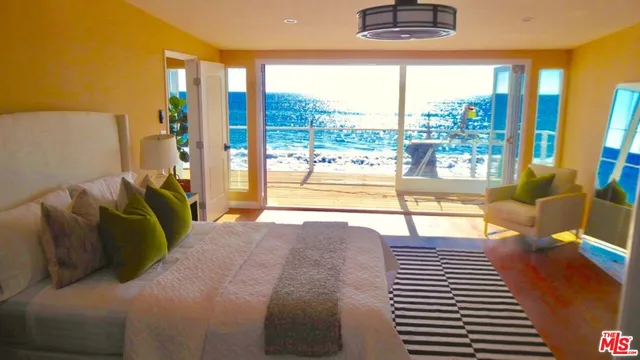 a bed sitting in a bedroom next to a large window