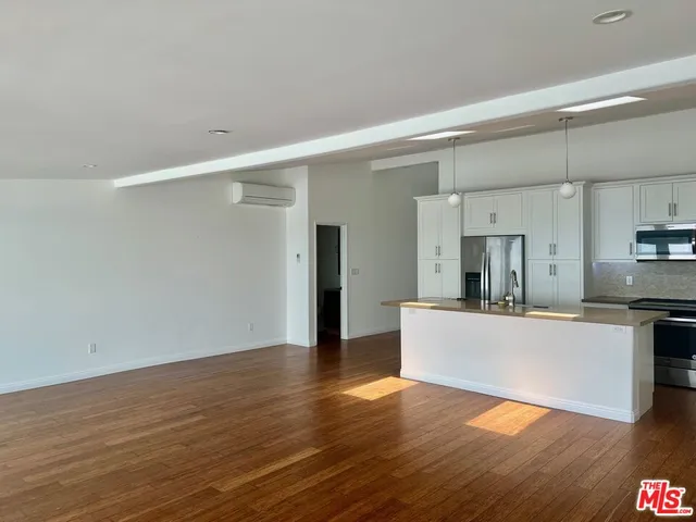 a view of a kitchen with wooden floor and a sink