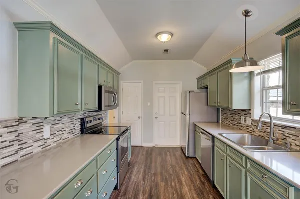 a kitchen with stainless steel appliances a stove sink microwave and cabinets