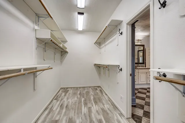 a spacious bathroom with a granite countertop sink a toilet a mirror and shower