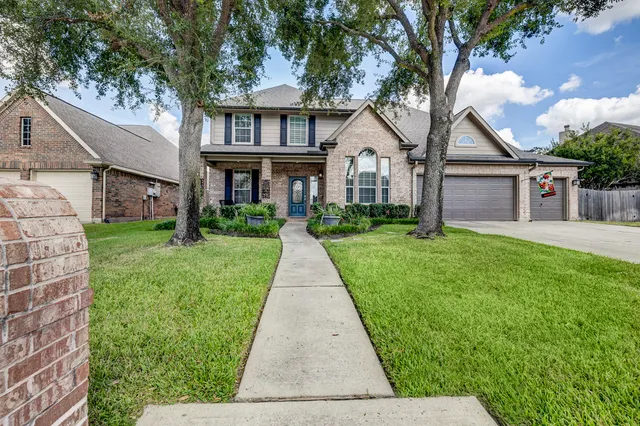 a front view of a house with a yard and potted plants