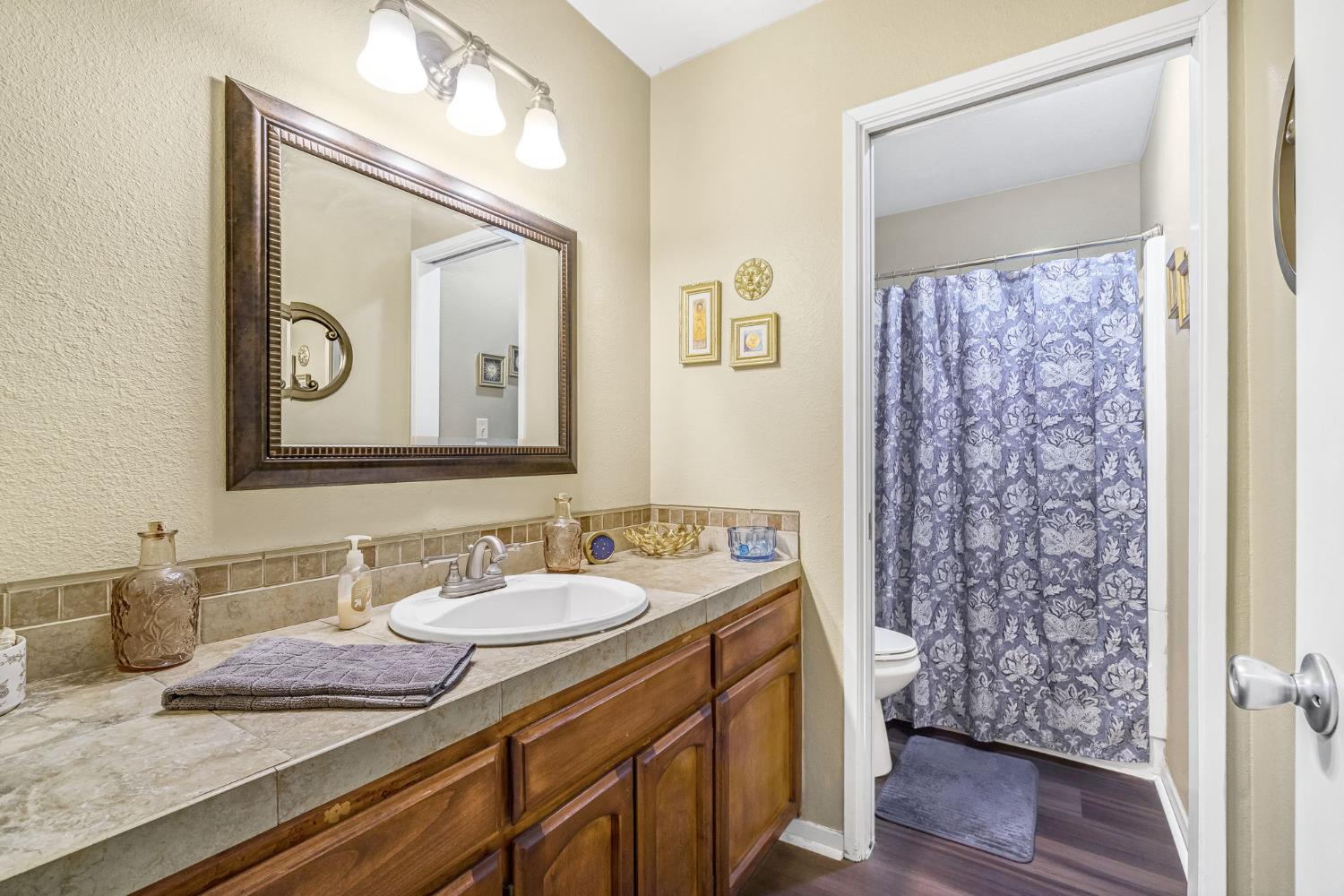 7675 North First Street, Unit 202 Fresno, CA 93720 - Photo 17 of 24 a bathroom with a granite countertop sink a mirror and a shower