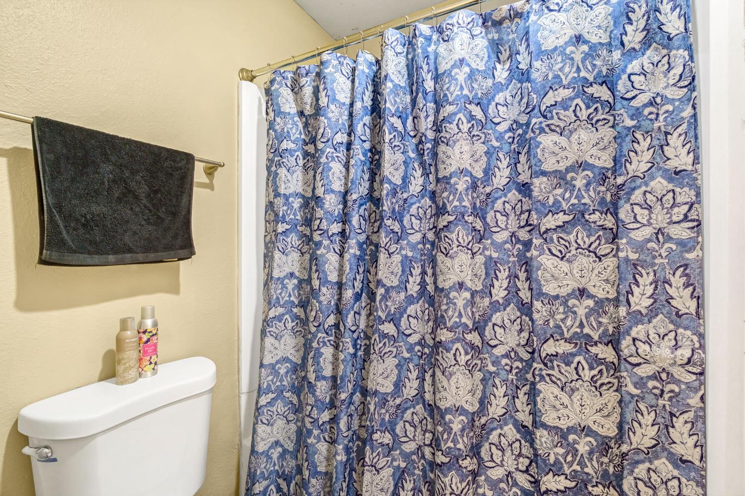 7675 North First Street, Unit 202 Fresno, CA 93720 - Photo 18 of 24 a bathroom with a toilet and a shower curtain