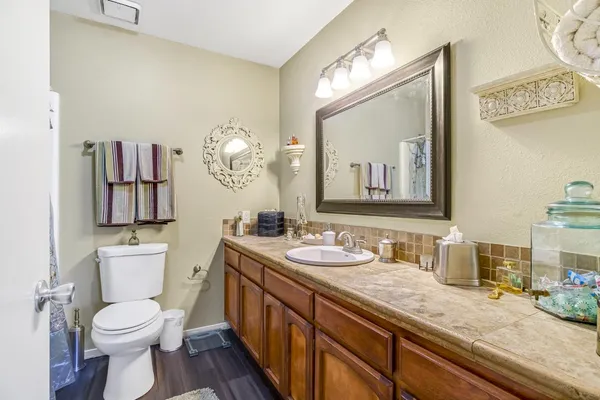 a bathroom with a sink a toilet and a mirror