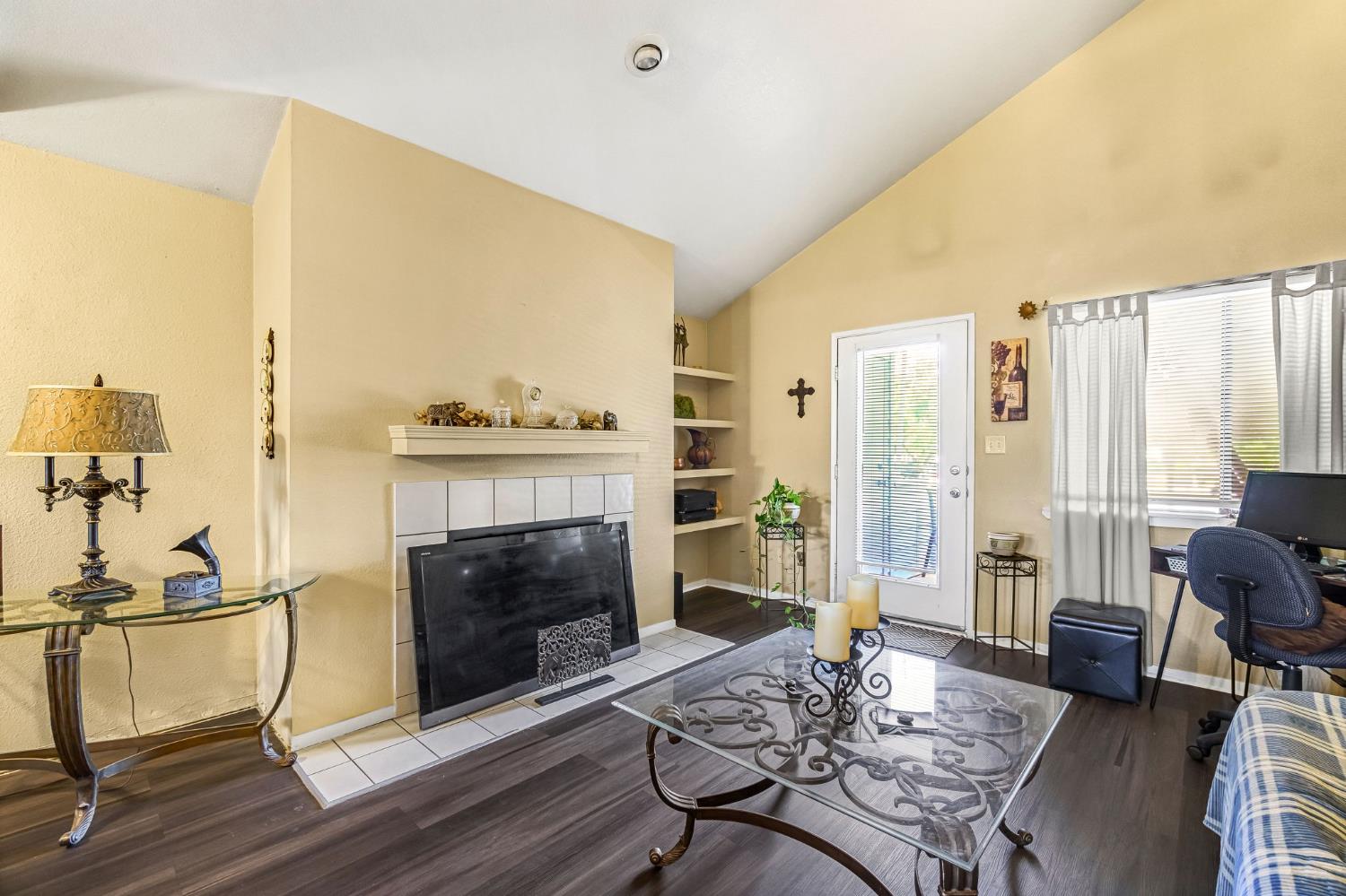 7675 North First Street, Unit 202 Fresno, CA 93720 - Photo 10 of 24 a living room with furniture a fireplace and a floor to ceiling window