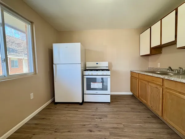 a kitchen with a refrigerator stove and wooden cabinets
