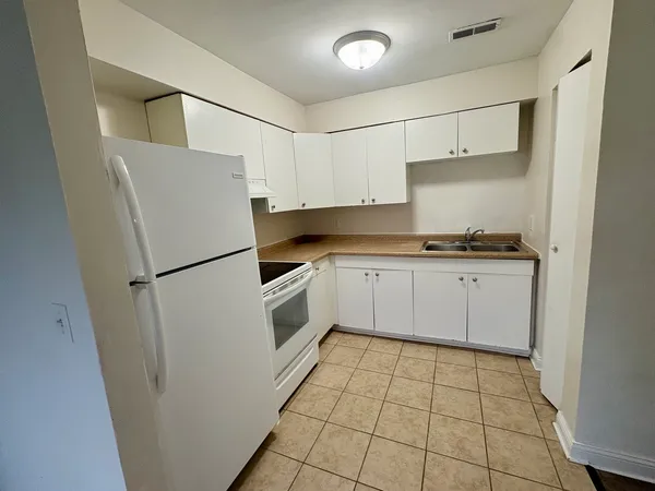 a kitchen with white cabinets a refrigerator a sink and a stove