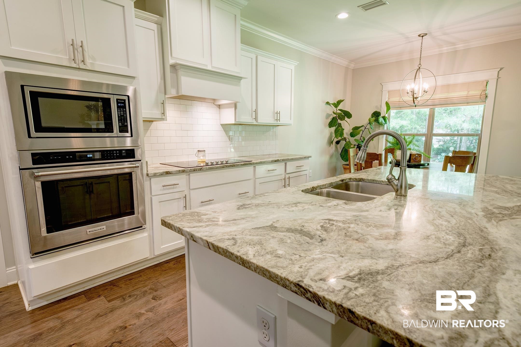 18754 Treasure Oaks Road Gulf Shores, AL 36542 - Photo 26 of 53 Kitchen featuring a large island with an undermount double basin sink and gooseneck faucet