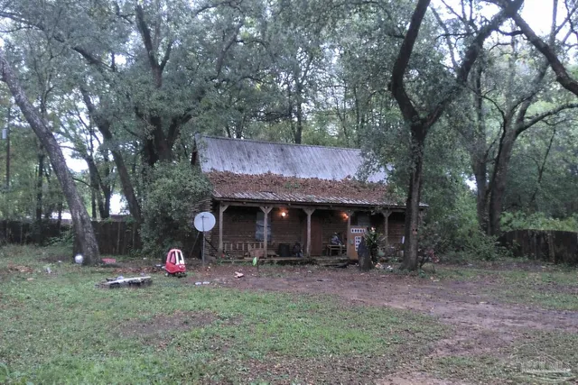 a view of a house with a backyard and tree