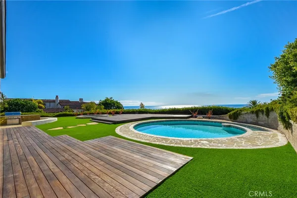 a view of a swimming pool with a yard and seating