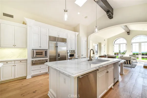 a dining room with furniture a chandelier and wooden floor
