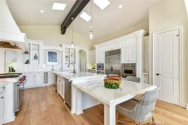 a kitchen with white cabinets and stainless steel appliances