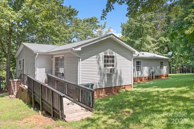 a front view of house with yard and trees in the background
