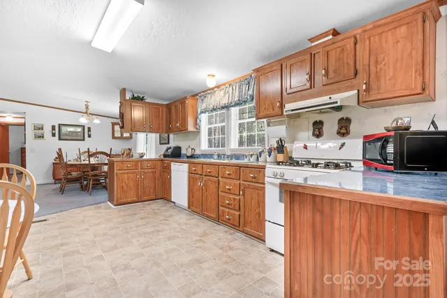 a kitchen with stainless steel appliances granite countertop a sink refrigerator and cabinets