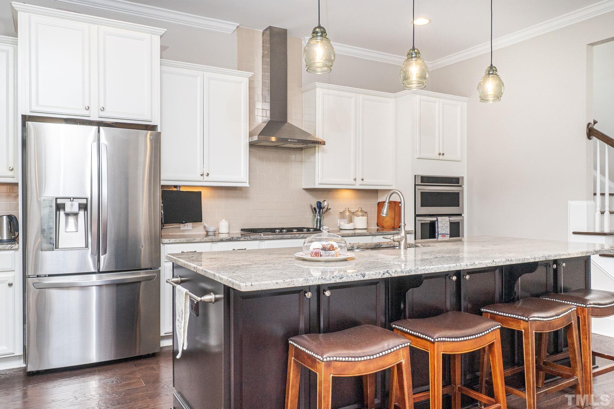 129 Penley Circle Raleigh, NC 27609 - Photo 19 of 43 a kitchen with stainless steel appliances granite countertop a table chairs stove and refrigerator