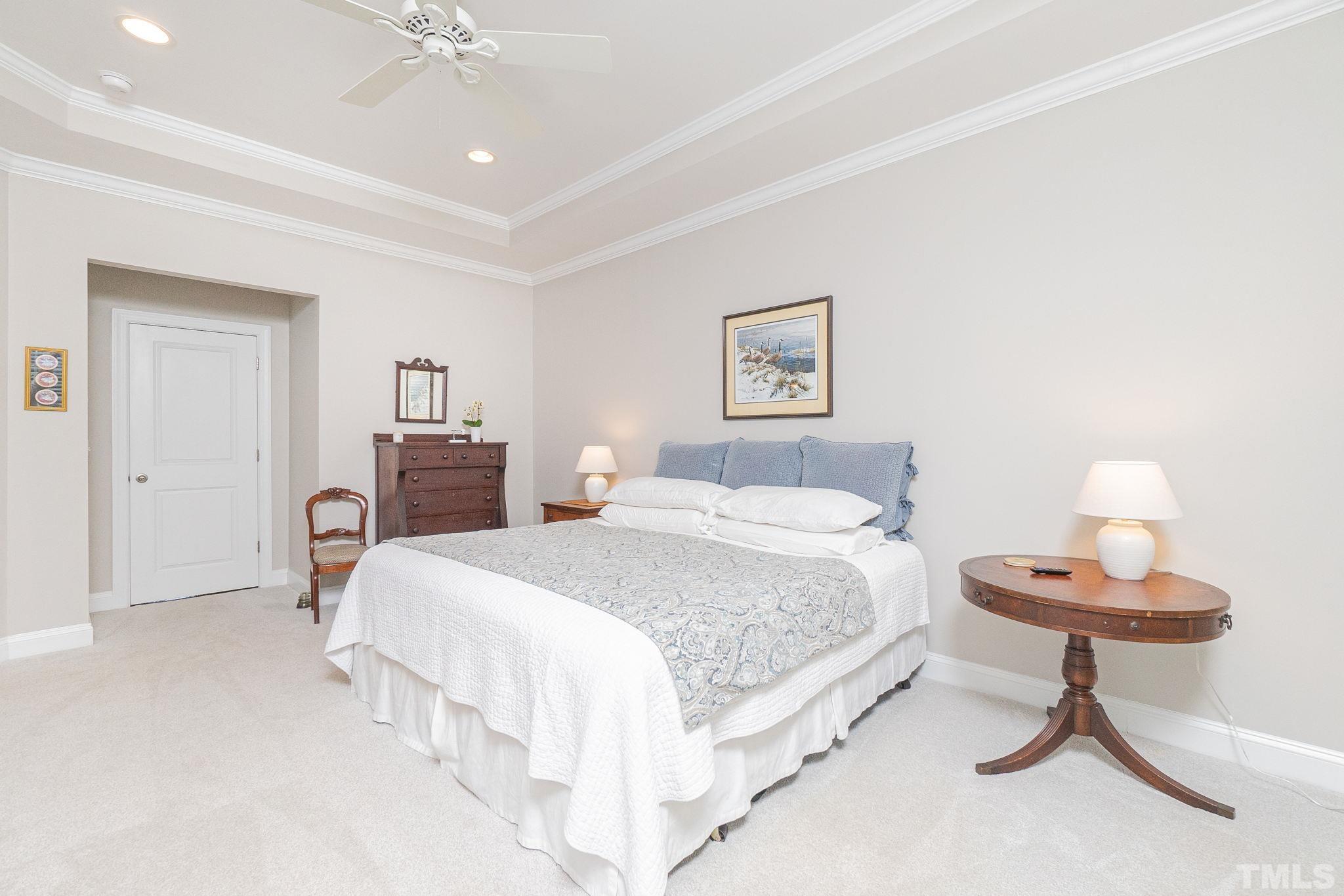 129 Penley Circle Raleigh, NC 27609 - Photo 31 of 43 a spacious bedroom with a bed and a chandelier