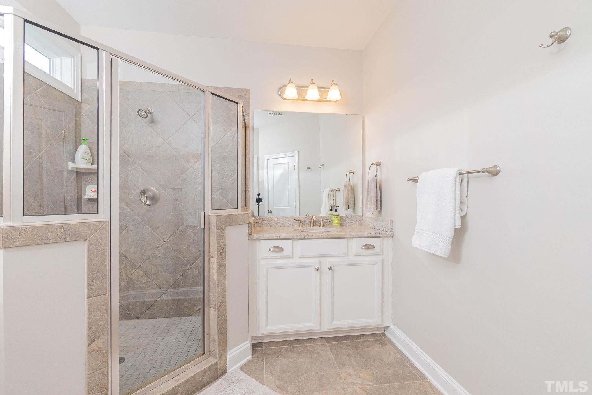 129 Penley Circle Raleigh, NC 27609 - Photo 34 of 43 a spacious bathroom with a shower sink and mirror