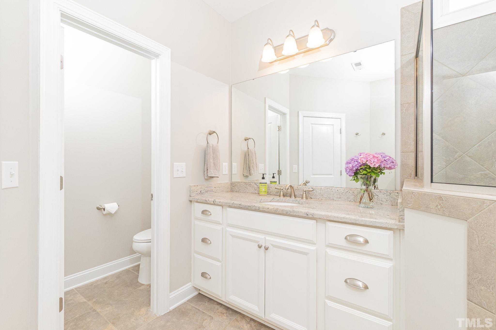 129 Penley Circle Raleigh, NC 27609 - Photo 35 of 43 a bathroom with a granite countertop sink and a mirror