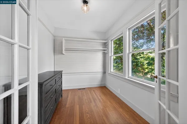 a view of walk in closet with wooden floor and fan